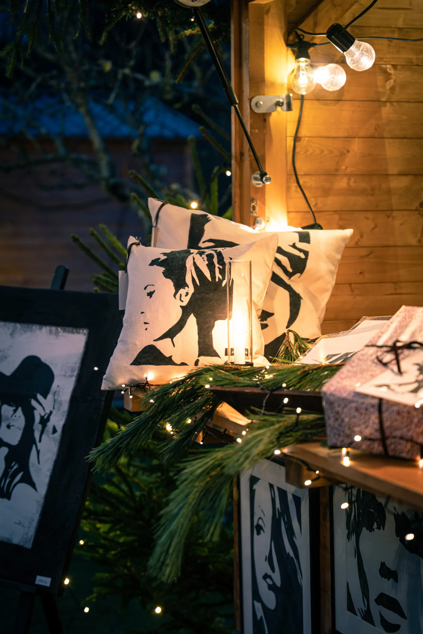 Tavlor och granris i en julmarknadsstuga