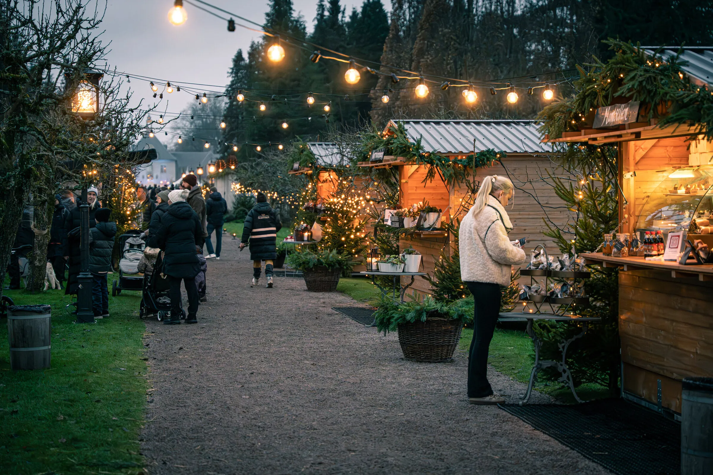 Besökare på gången mellan julmarknadsstugorna
